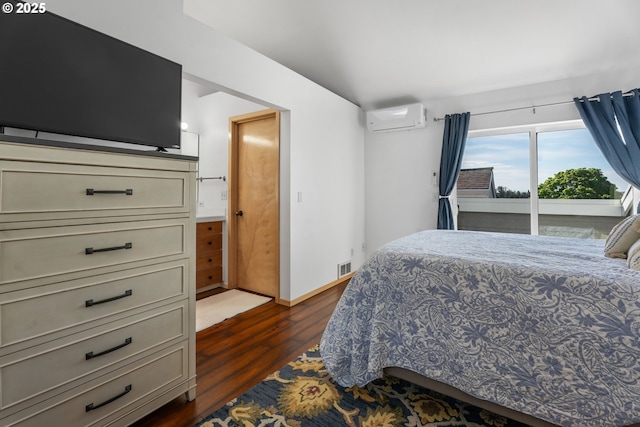 bedroom featuring a wall mounted AC, dark wood-style floors, and baseboards