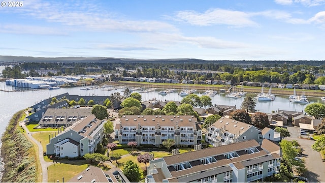aerial view of a nearby body of water, apartment complex / building, and a marina