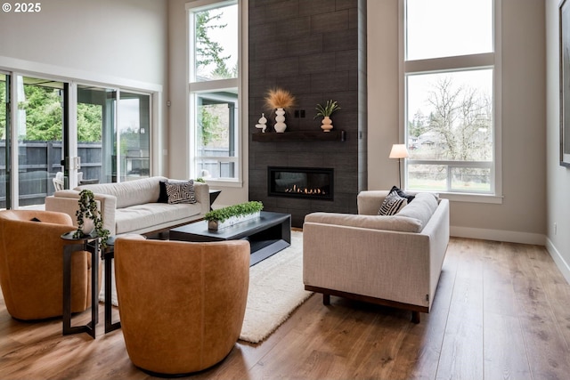 1006 S 48th Pl, Ridgefield, WA 98642 - living room with healthy amount of natural light, a fireplace, wood finished floors, a towering ceiling, and baseboards