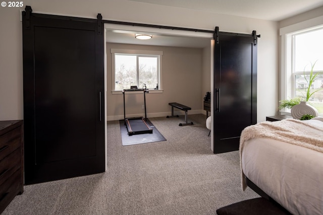 1006 S 48th Pl, Ridgefield, WA 98642 - carpeted bedroom featuring a barn door and baseboards