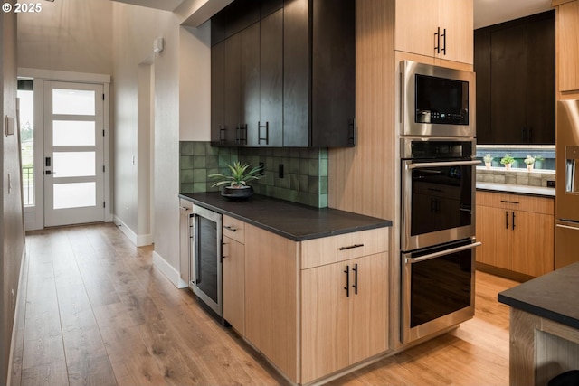 1006 S 48th Pl, Ridgefield, WA 98642 - kitchen featuring beverage cooler, stainless steel appliances, light wood-type flooring, and dark countertops