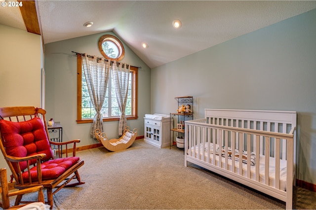 bedroom with lofted ceiling, carpet, and a crib