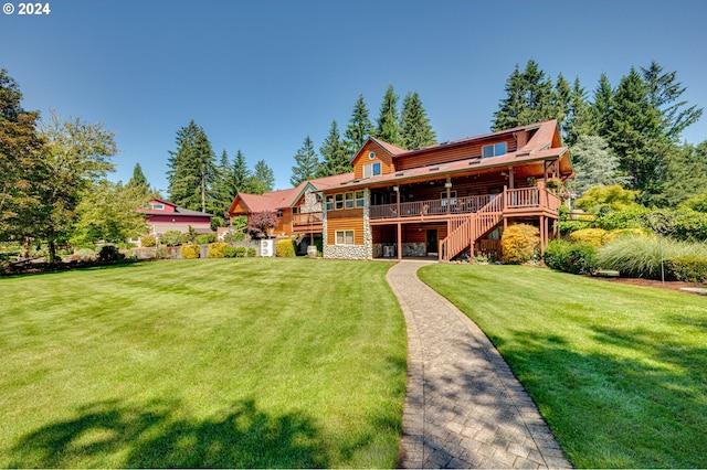 rear view of house featuring a deck and a lawn