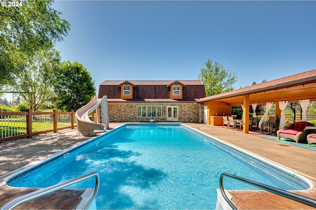 view of pool featuring a patio and a water slide