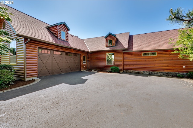 log-style house with a garage