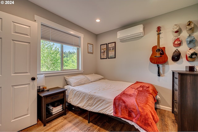 bedroom featuring a wall unit AC and light hardwood / wood-style flooring