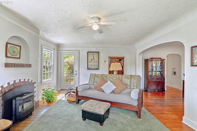 living area featuring a textured ceiling, ceiling fan, and baseboards