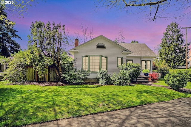 single story home with a yard, fence, and a chimney