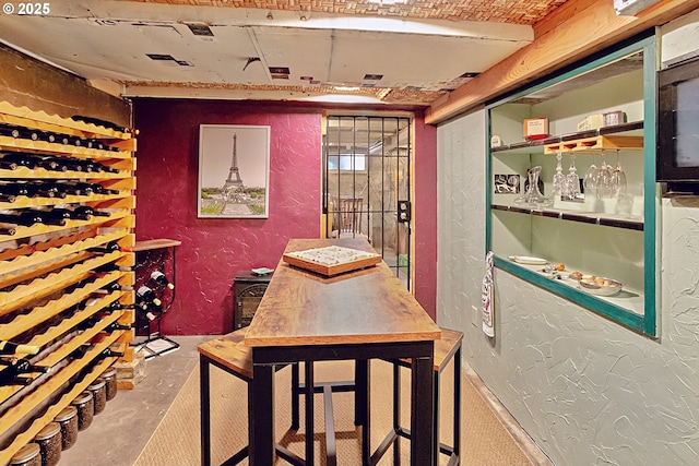 wine area with a textured wall and concrete floors