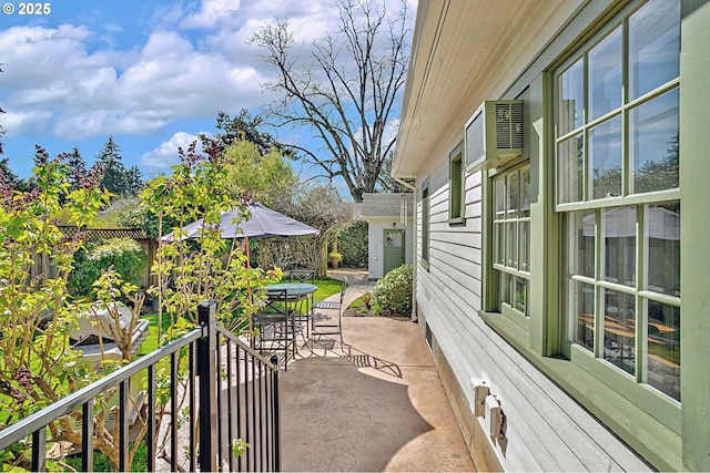 view of patio with a wall mounted AC and outdoor dining space