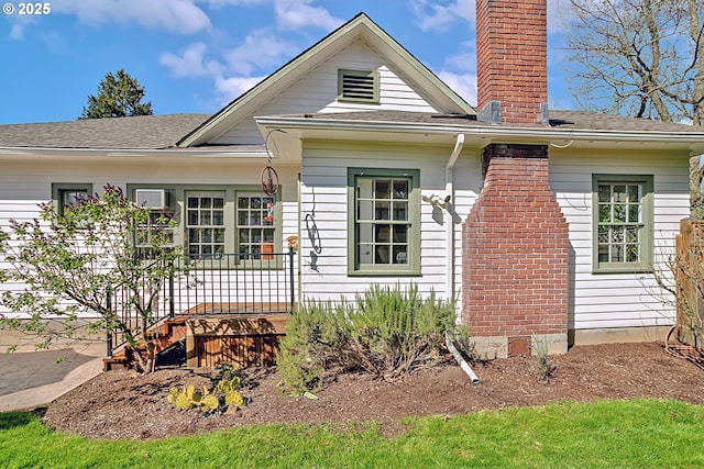 view of front of property with roof with shingles and a chimney