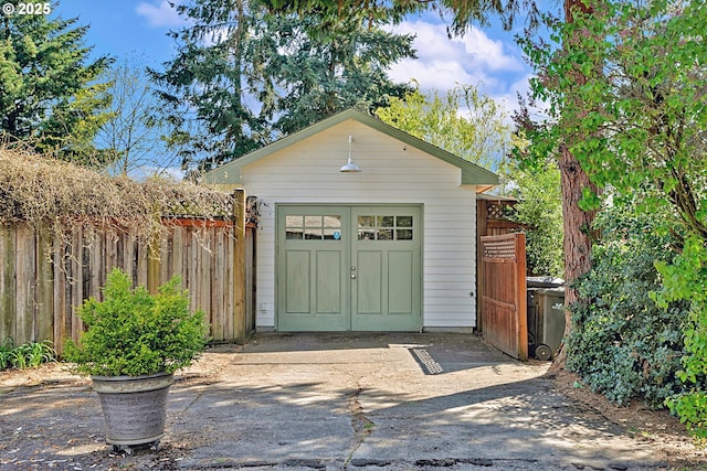 view of outdoor structure with fence and an outbuilding