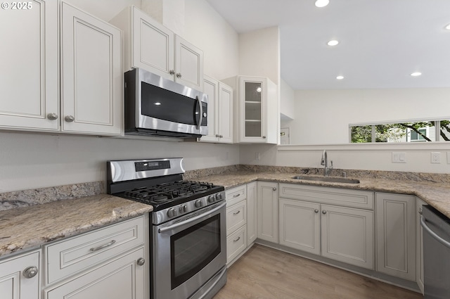 1397 Bonniebrae Dr, Lake Oswego, OR 97034 - kitchen with appliances with stainless steel finishes, a sink, light wood-style flooring, recessed lighting, and glass insert cabinets
