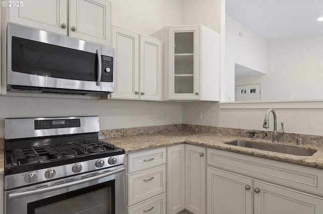 1397 Bonniebrae Dr, Lake Oswego, OR 97034 - kitchen with appliances with stainless steel finishes, a sink, glass insert cabinets, and light stone countertops