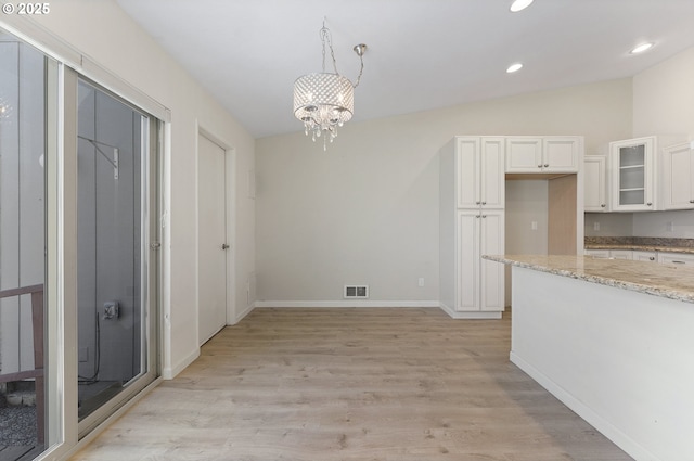1397 Bonniebrae Dr, Lake Oswego, OR 97034 - kitchen featuring white cabinetry, light wood finished floors, glass insert cabinets, light stone countertops, and a chandelier