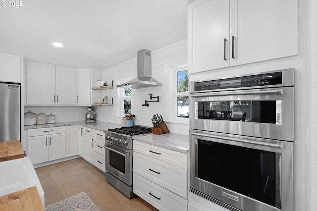 1069 Little Valley Rd, Roseburg, OR 97471 - kitchen featuring stainless steel appliances, wall chimney range hood, white cabinetry, and recessed lighting