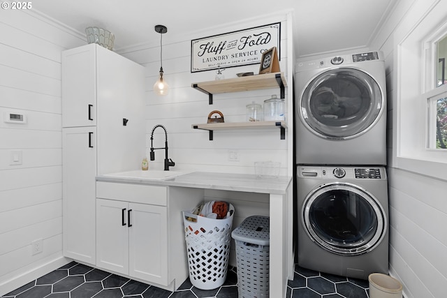 1069 Little Valley Rd, Roseburg, OR 97471 - washroom with estacked washer and dryer, dark tile patterned floors, cabinet space, wooden walls, and crown molding