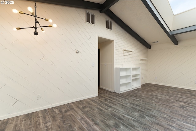 1260 Jackson Ave, Bandon, OR 97411 - spare room featuring a skylight, wood walls, a chandelier, and dark wood finished floors