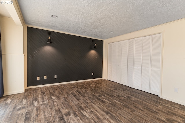 1260 Jackson Ave, Bandon, OR 97411 - unfurnished bedroom featuring wood finished floors, a textured ceiling, and wooden walls