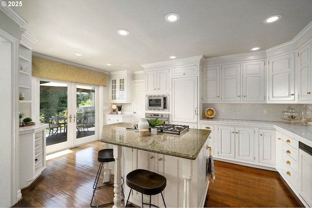 2892 NW Beuhla Vista Ter, Portland, OR 97210 - kitchen with appliances with stainless steel finishes, white cabinets, ornamental molding, a kitchen bar, and recessed lighting