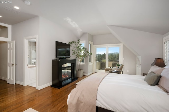 2892 NW Beuhla Vista Ter, Portland, OR 97210 - bedroom with access to exterior, wood finished floors, vaulted ceiling, a glass covered fireplace, and recessed lighting