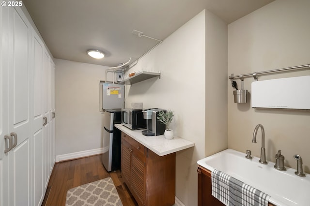 2892 NW Beuhla Vista Ter, Portland, OR 97210 - kitchen featuring a sink, stainless steel microwave, dark wood finished floors, light countertops, and baseboards