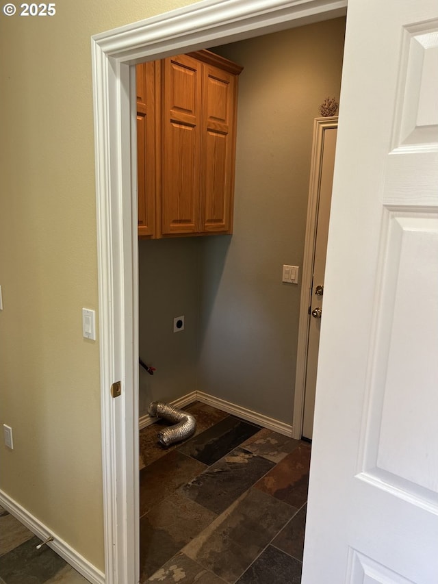 washroom with cabinet space, electric dryer hookup, stone finish flooring, and baseboards
