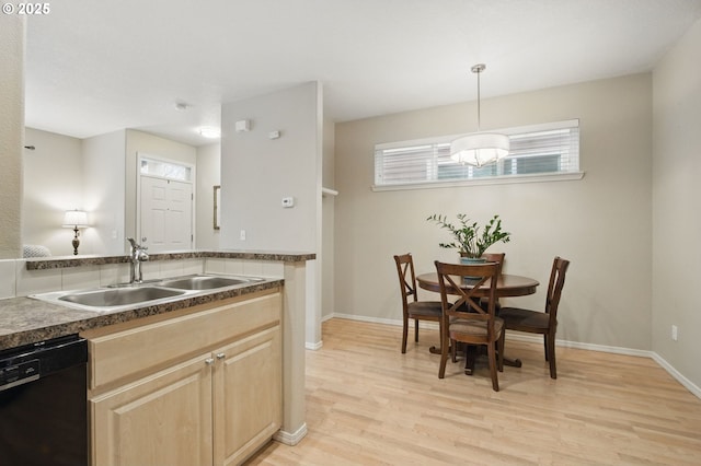 1639 SW 171st Ter, Beaverton, OR 97003 - kitchen with light brown cabinetry, a sink, black dishwasher, light wood finished floors, and baseboards