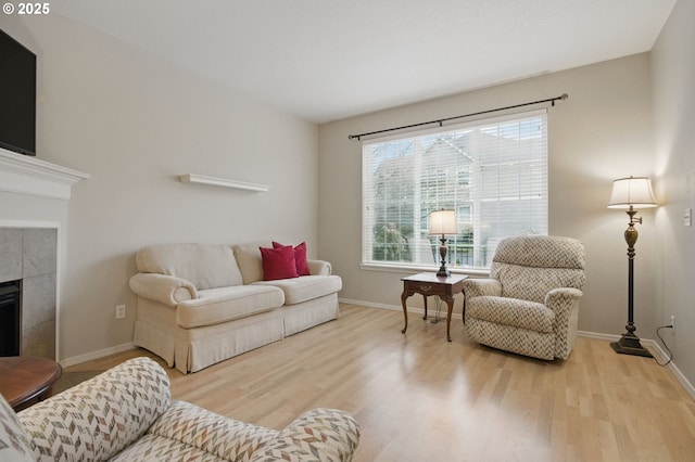 1639 SW 171st Ter, Beaverton, OR 97003 - living area with a tiled fireplace, wood finished floors, and baseboards