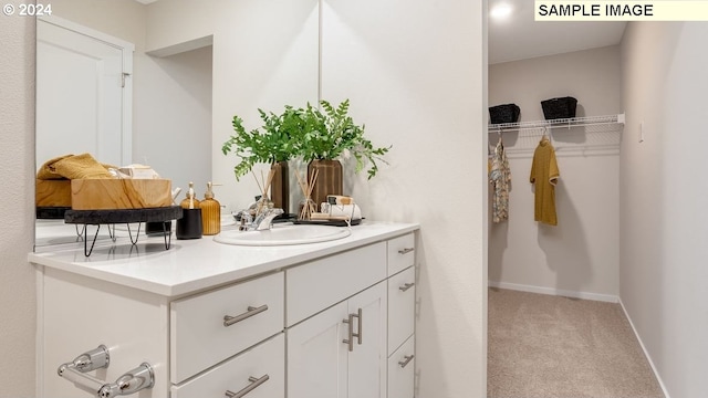 walk in closet with light carpet and sink