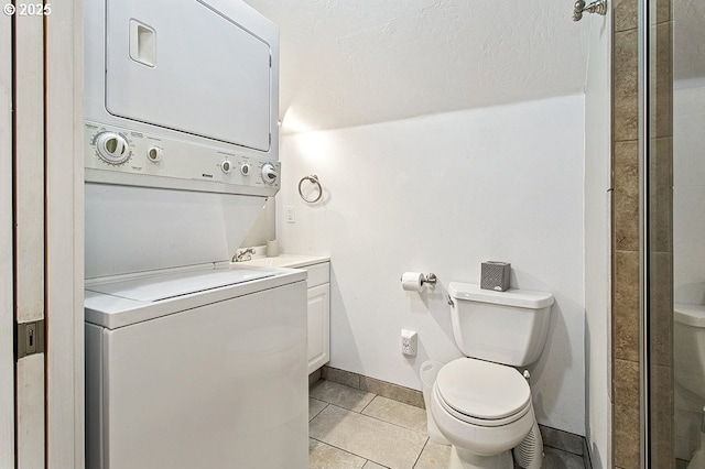 13616 SE Rhine St, Portland, OR 97236 - full bathroom featuring stacked washing machine and dryer, vanity, tile patterned flooring, a stall shower, and toilet