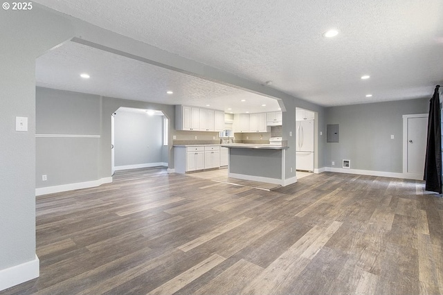 13616 SE Rhine St, Portland, OR 97236 - unfurnished living room with a textured ceiling, arched walkways, wood finished floors, baseboards, and electric panel