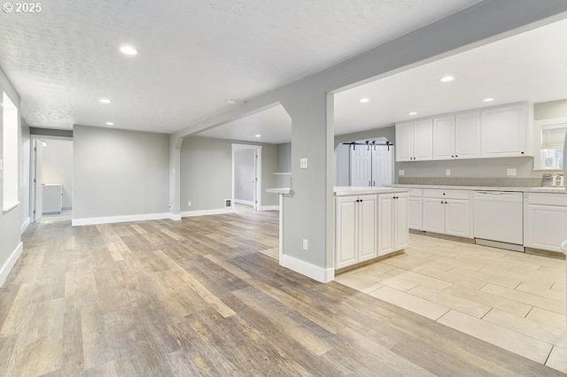 13616 SE Rhine St, Portland, OR 97236 - kitchen featuring dishwasher, light wood-style floors, light countertops, white cabinets, and recessed lighting