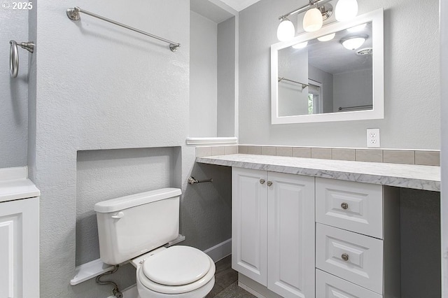 13616 SE Rhine St, Portland, OR 97236 - bathroom featuring toilet, vanity, a textured wall, and baseboards