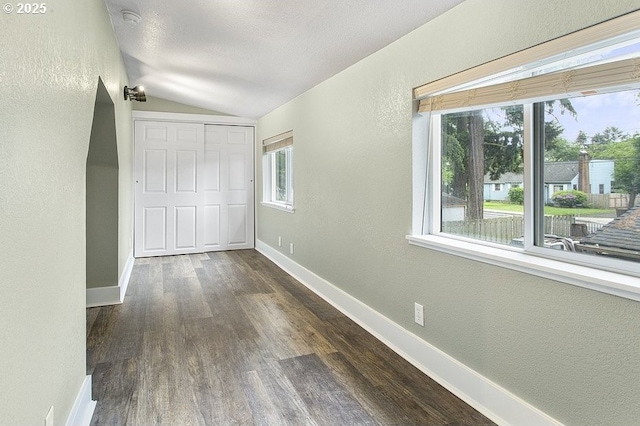 13616 SE Rhine St, Portland, OR 97236 - corridor with a textured wall, vaulted ceiling, dark wood-style flooring, and baseboards