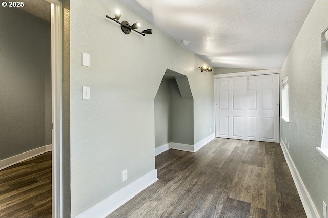 13616 SE Rhine St, Portland, OR 97236 - additional living space featuring dark wood-type flooring, arched walkways, baseboards, a textured wall, and a textured ceiling