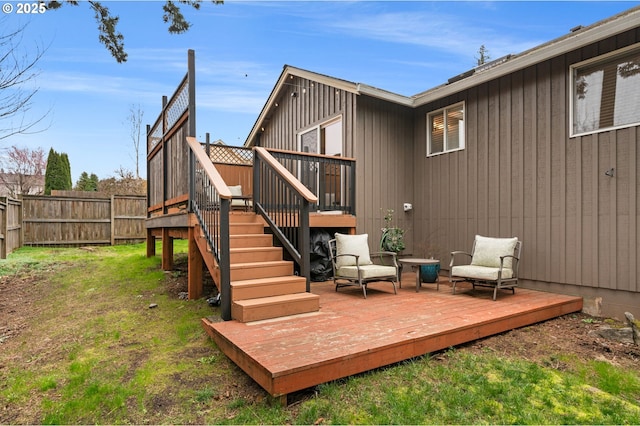 exterior space featuring a lawn, stairs, a deck, and fence