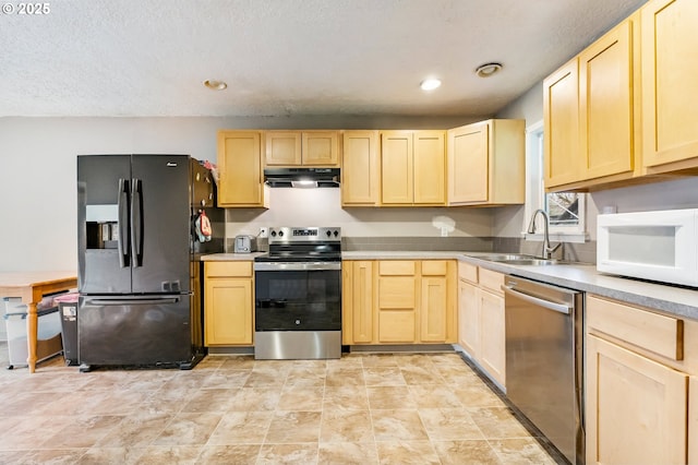 kitchen featuring under cabinet range hood, stainless steel appliances, light brown cabinets, and a sink