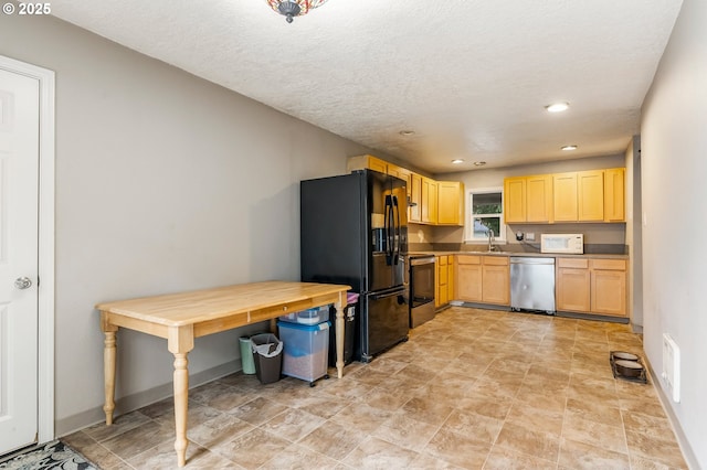 kitchen with a sink, baseboards, appliances with stainless steel finishes, and light brown cabinetry