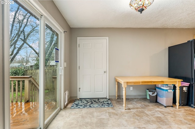 interior space with a textured ceiling and baseboards