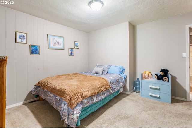 carpeted bedroom with baseboards and a textured ceiling