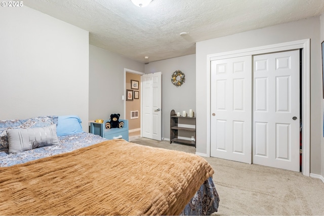 bedroom with visible vents, light carpet, a textured ceiling, and baseboards