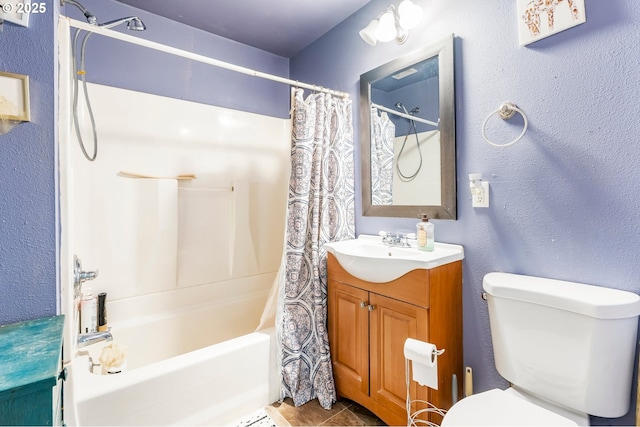 full bath with toilet, shower / bath combo, vanity, and a textured wall