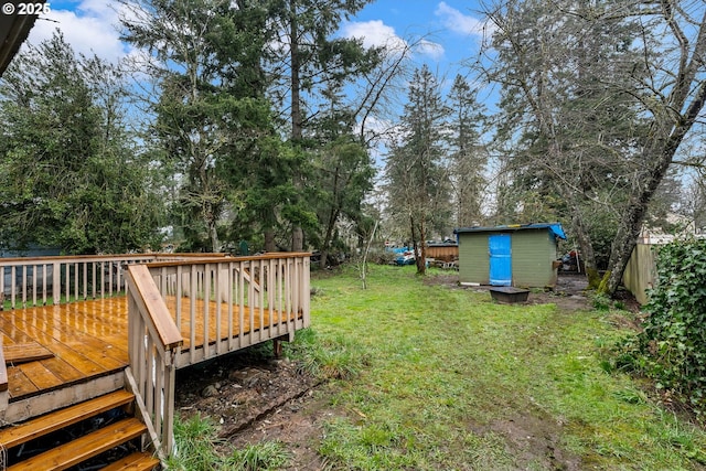 view of yard featuring a deck, an outdoor structure, and a shed