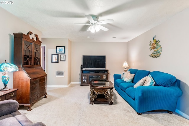 carpeted living room featuring visible vents, a textured ceiling, baseboards, and ceiling fan