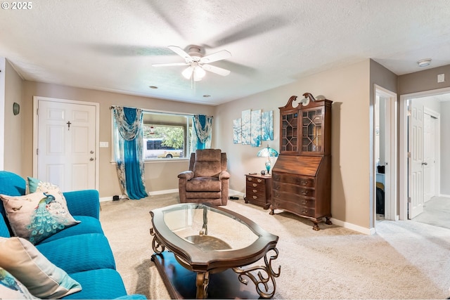 carpeted living room with baseboards, a textured ceiling, and a ceiling fan