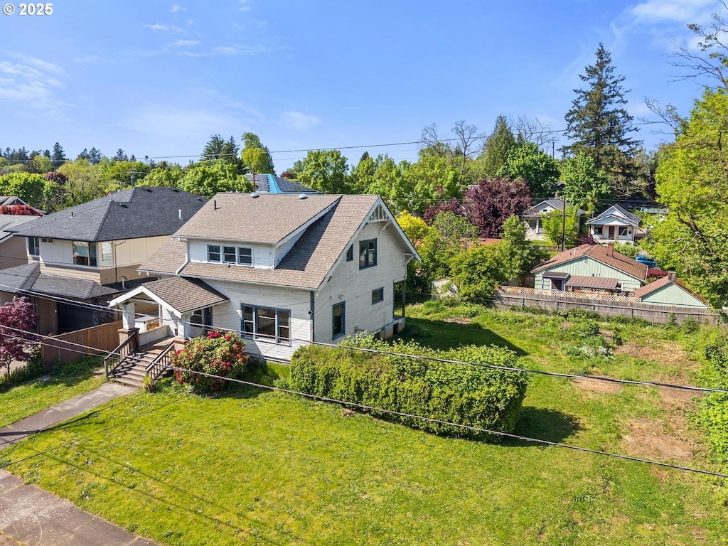 exterior space with roof with shingles and fence