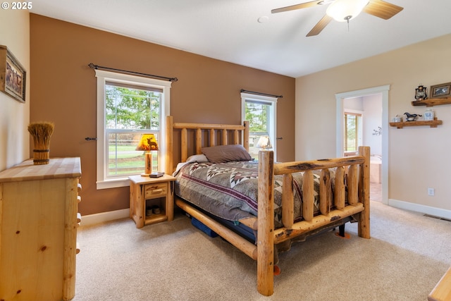 bedroom featuring visible vents, multiple windows, light colored carpet, and baseboards