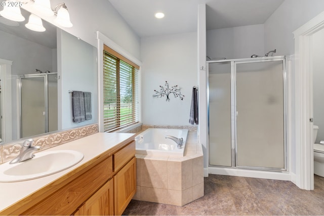 bathroom with toilet, a stall shower, vanity, and a bath