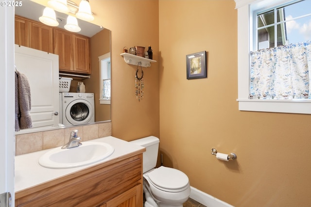 half bathroom featuring vanity, washer / dryer, a notable chandelier, and toilet